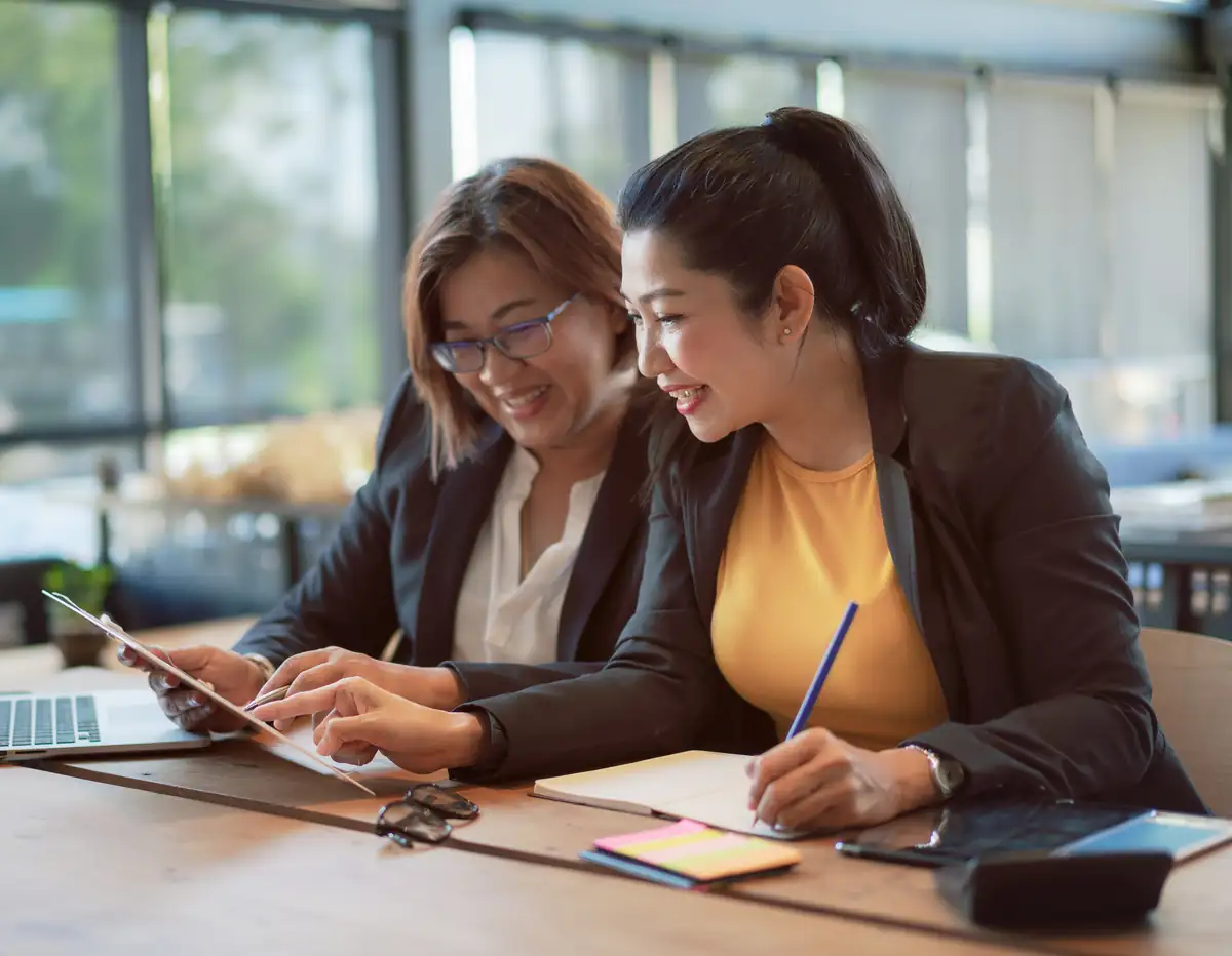 Two women colleagues working together at a laptop